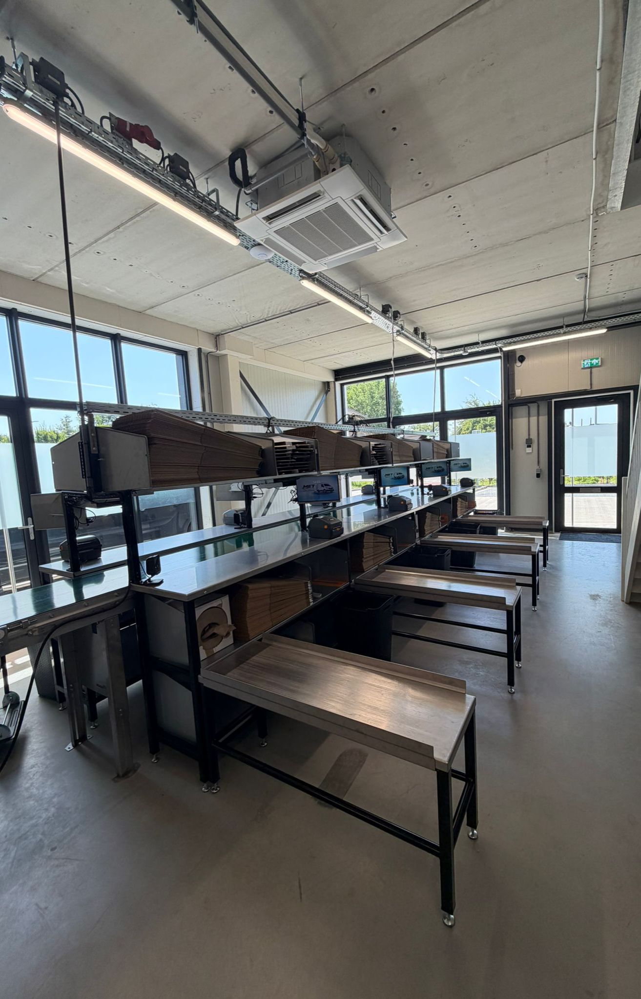 Inpakwerkstations met MET Logistics schermen en labelprinters
