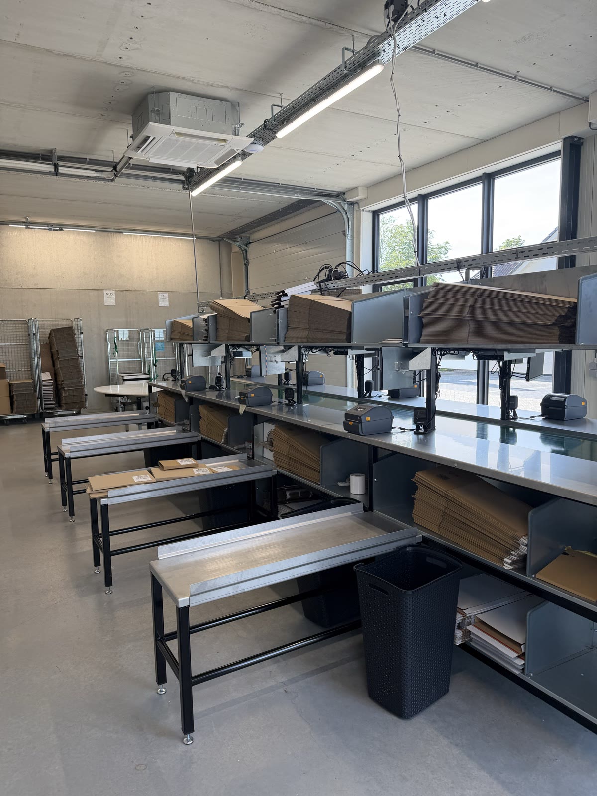 Overzicht van de inpaklijn met werkstations in het magazijn